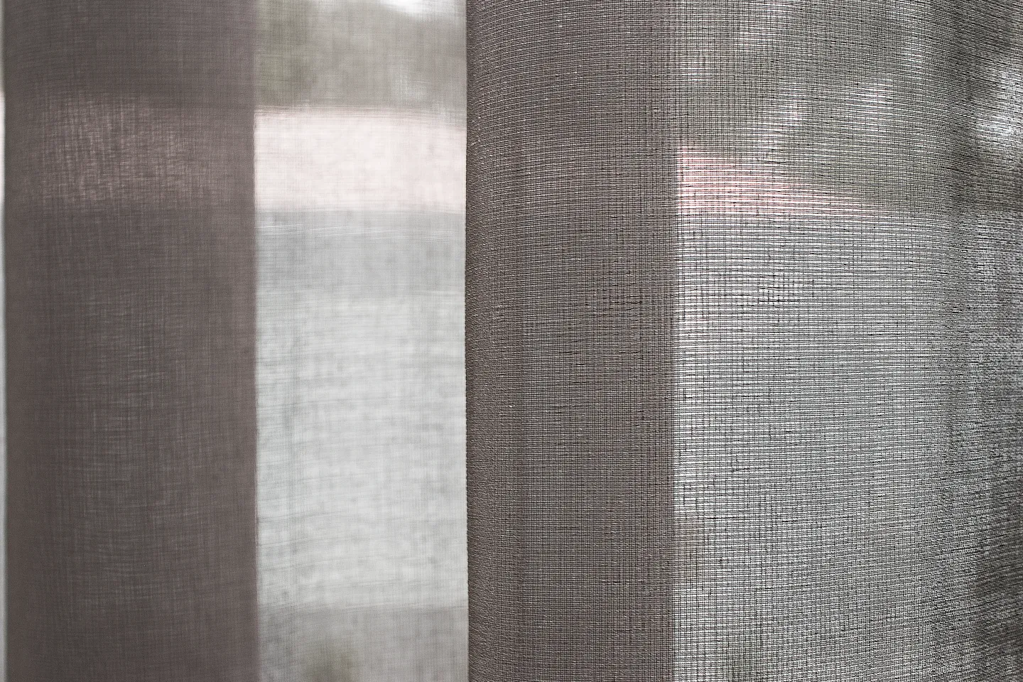 Close view of sheer curtain weave against daylight