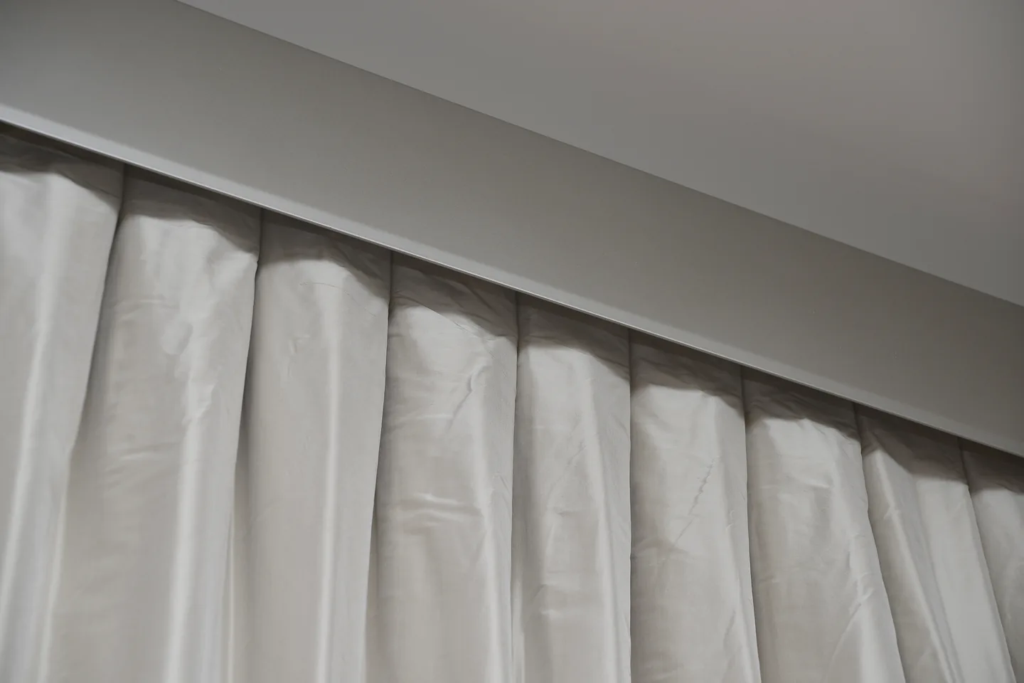 Close view of the pleated heading on a cream curtain