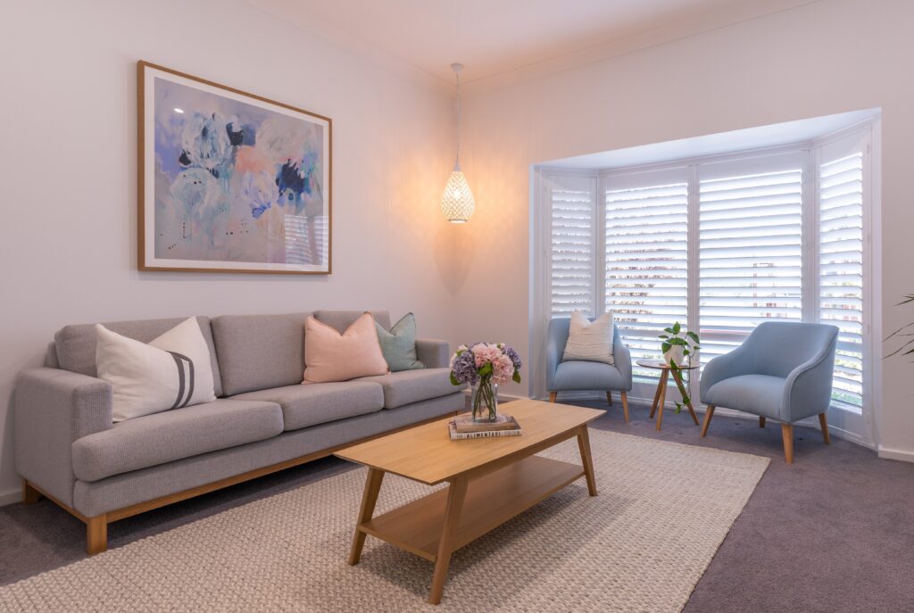 White plantation shutters across a bay window in a living room