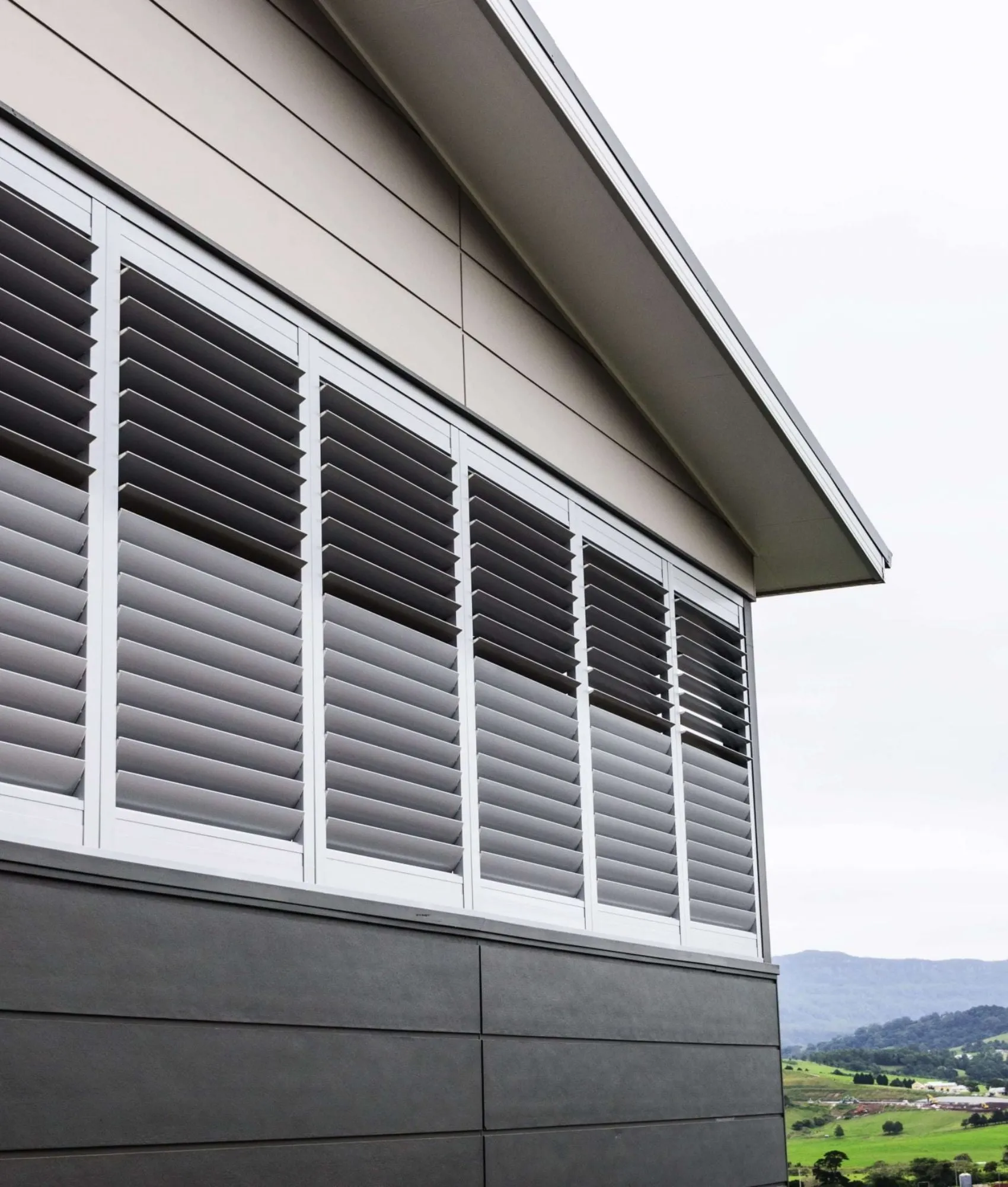 Fixed louvre aluminium shutters on a weatherboard home