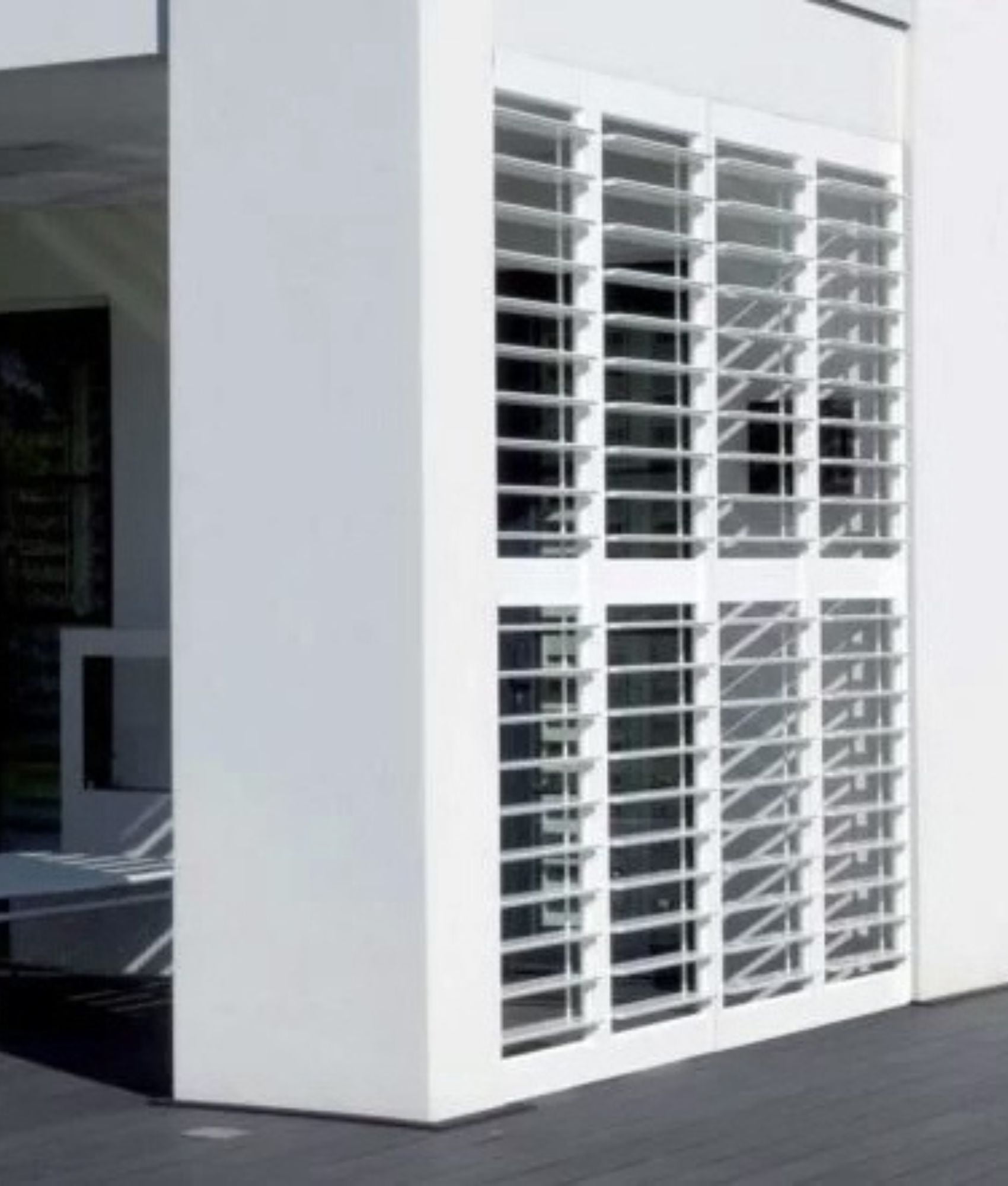 White aluminium plantation shutters on an outdoor deck
