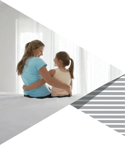 Mother and daughter sitting together in a bright bedroom