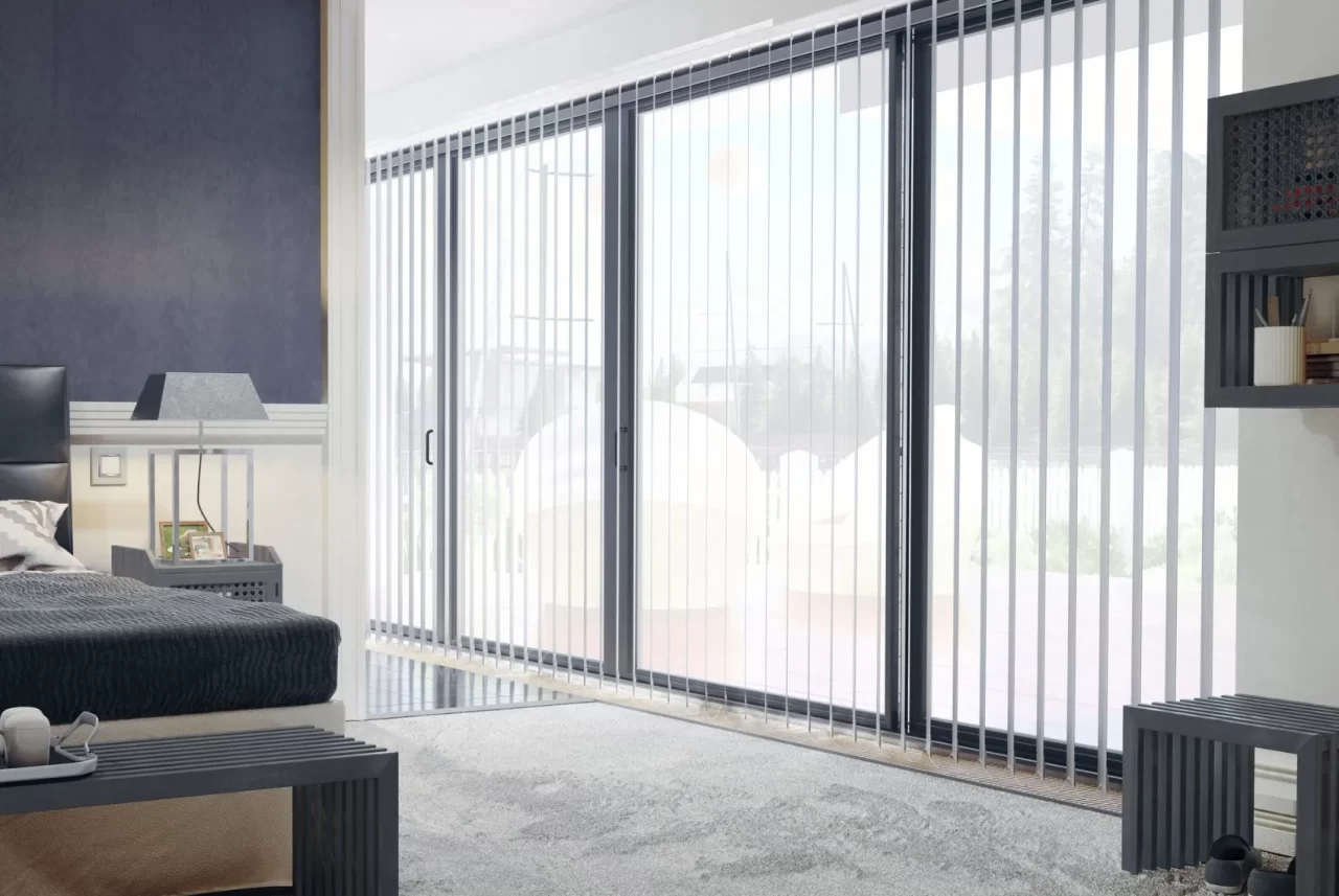 White vertical blinds across floor-to-ceiling sliding doors in a bedroom