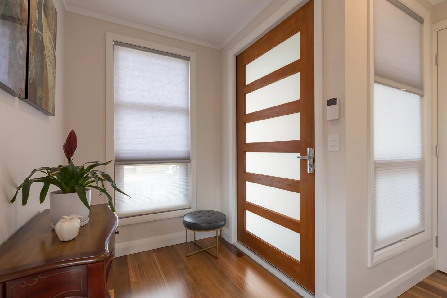 White honeycomb blinds lowered across the windows of a living area