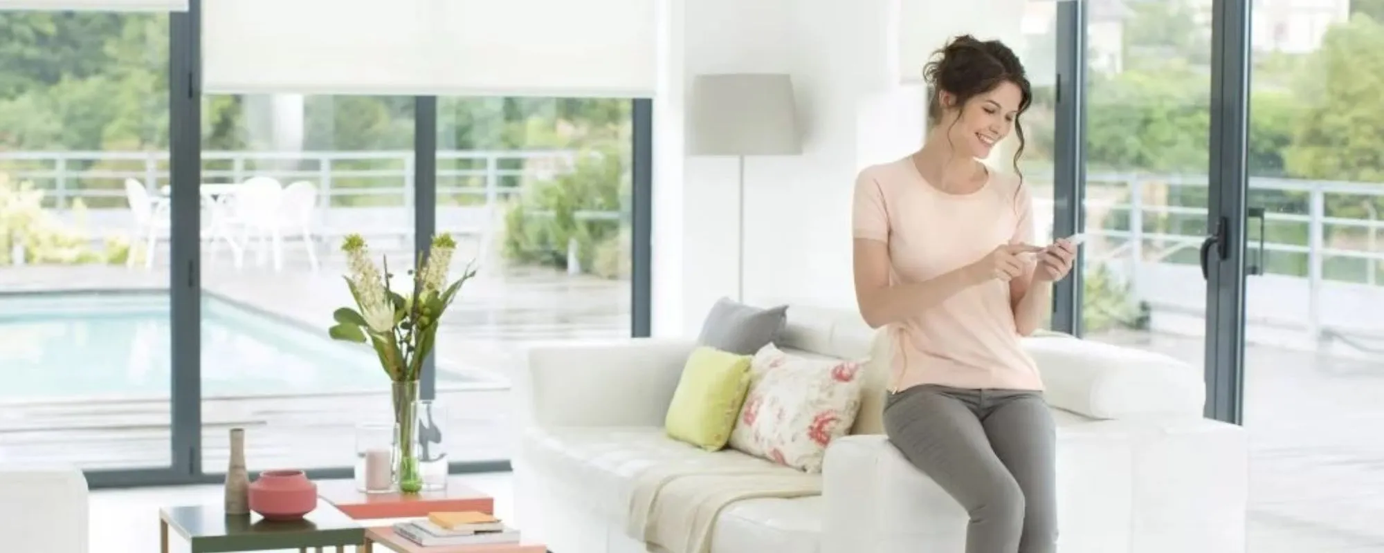 Living room with roller blinds and a person using a tablet