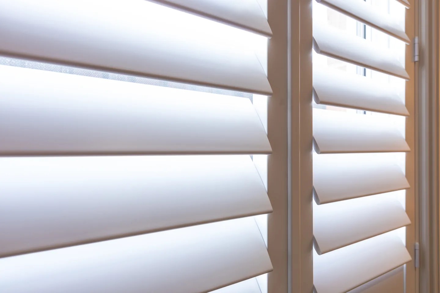 Close view of plantation shutter louvres tilted open, with the panel stile at the side