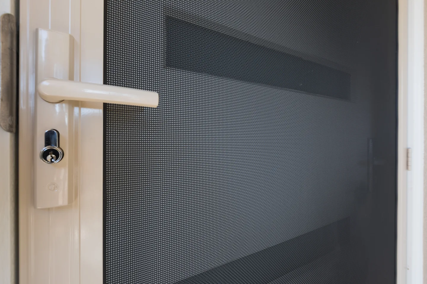 Lever handle and keyed lock on the stile of a cream-framed Crimsafe security door