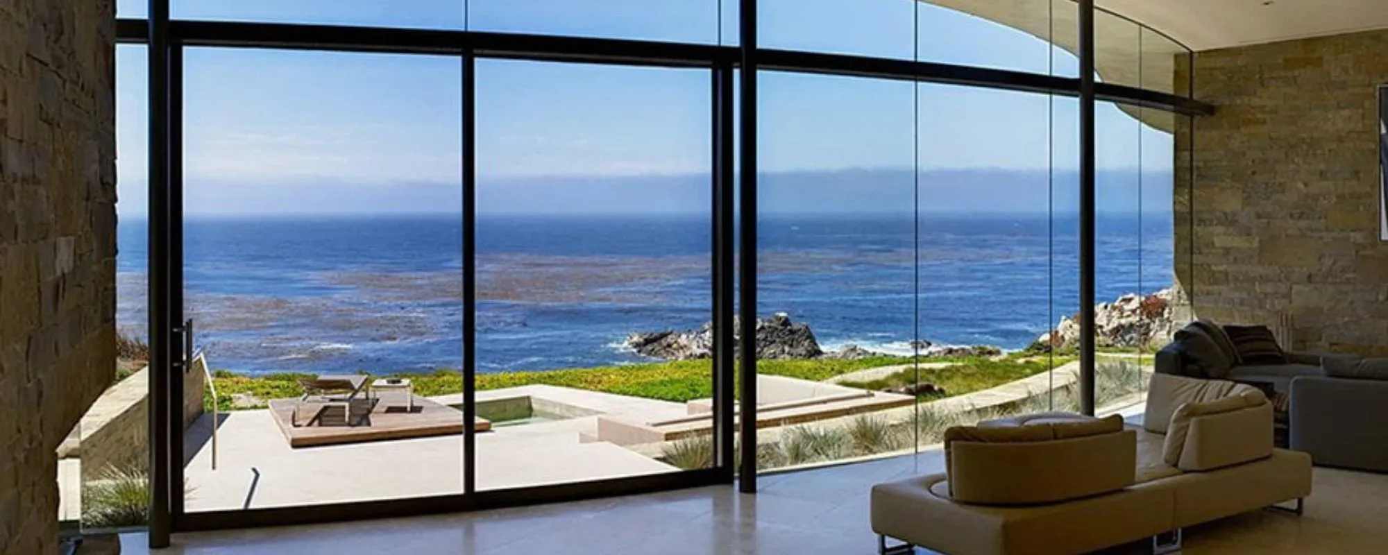 Living room with floor-to-ceiling glass overlooking the sea