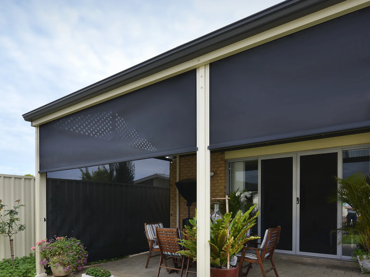A patio with the outdoor blind raised, showing the sliding door behind