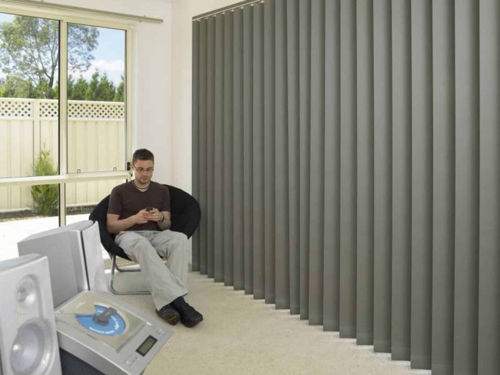 Stanbond SA - Blinds Adelaide - Image of man relaxing in living room with vertical shade blinds